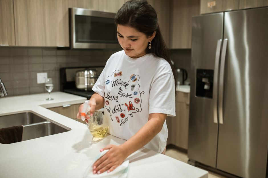 House cleaner meticulously wiping down a kitchen counter